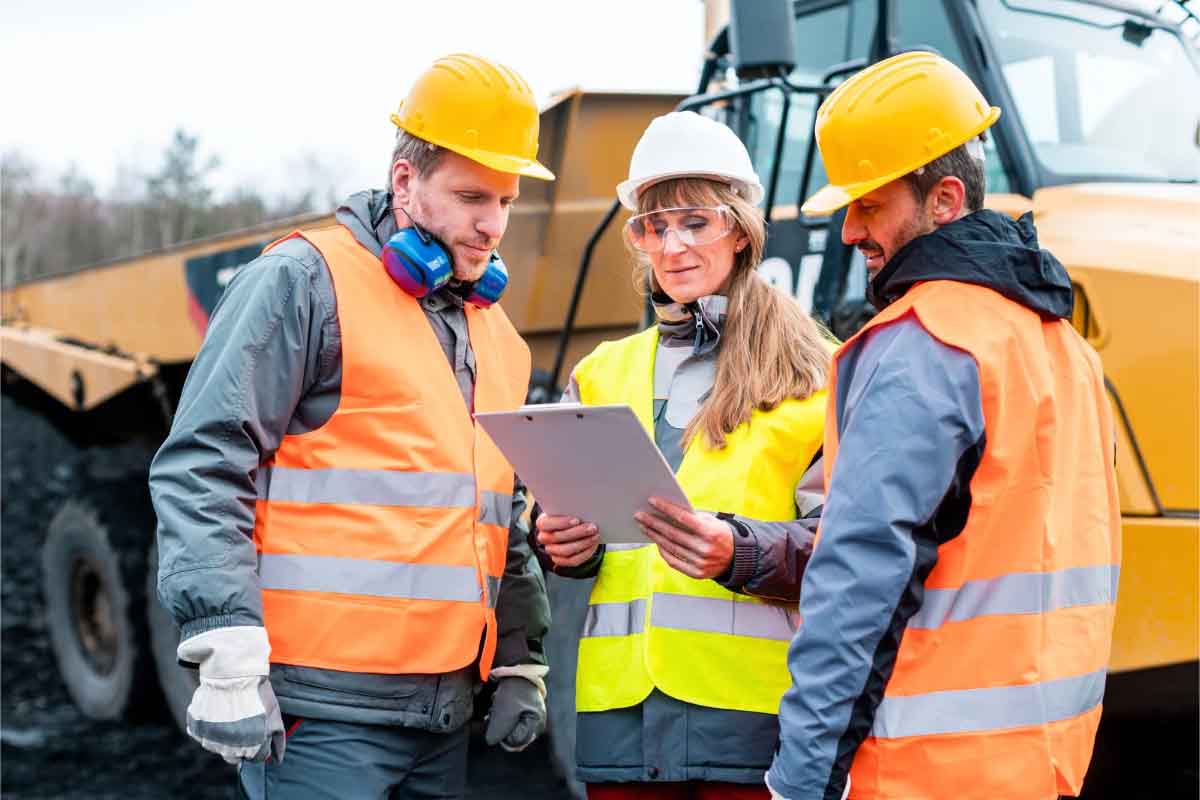 Three workers in a high risk industry wearing high-vis vests and hard hats